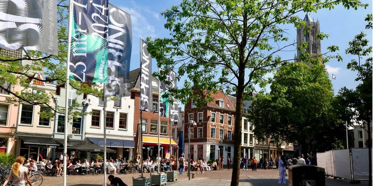 Link naar foto in Flickr: mensen in de zon op het terras in de Korte Minrebroederstraat tegenover het stadhuis.