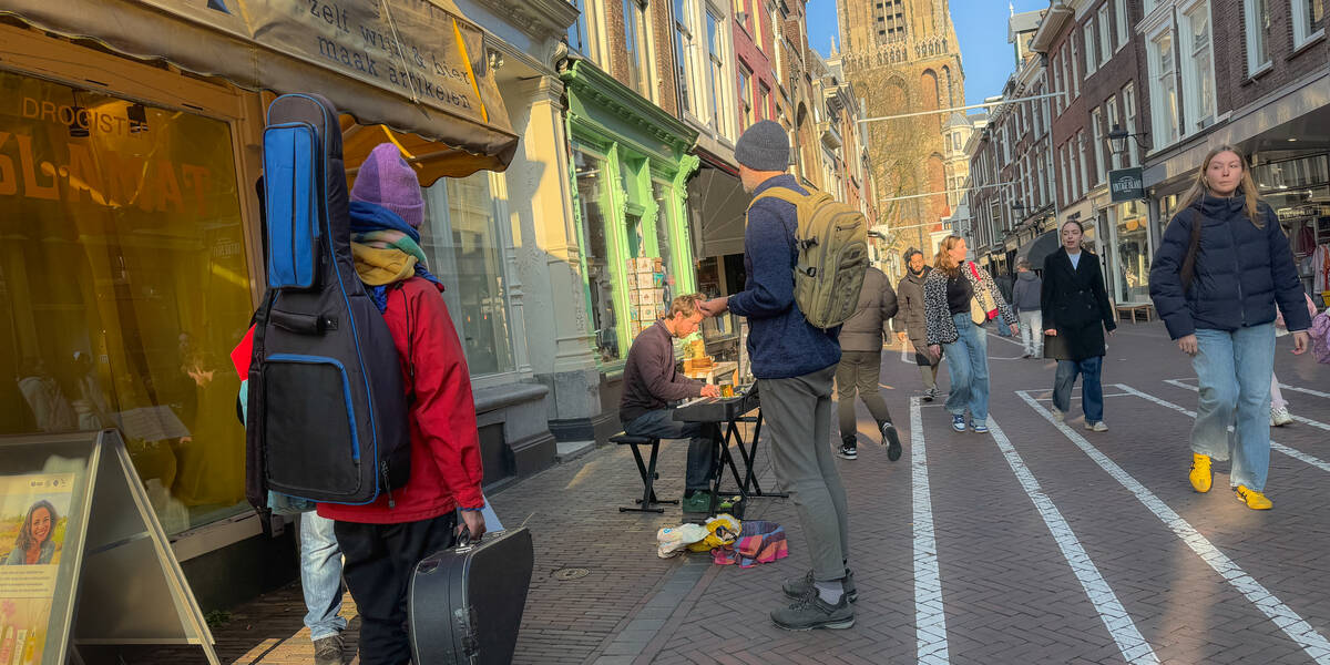 Link naar foto in Flickr: winkelend publiek in de Zadelstraat op de achtergrond de Domtoren..