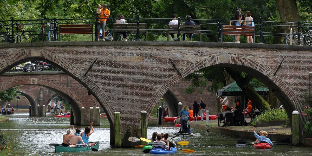 Link naar foto in Flickr: mensen in kano's in de Oudegracht zwaaien naar mensen op de Weesbrug.