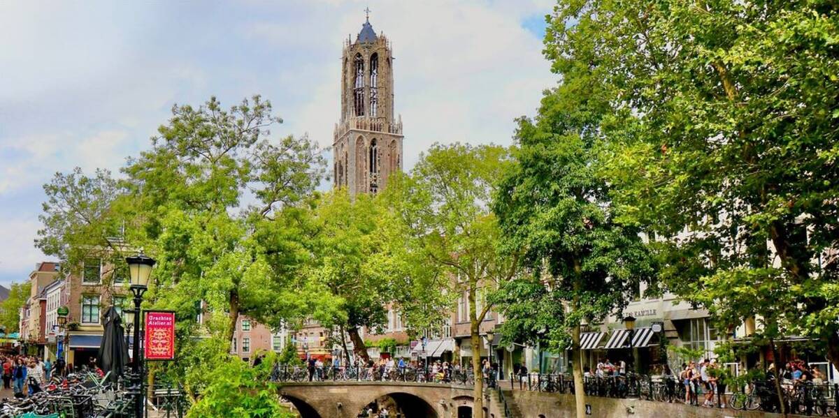 Link naar foto in Flickr: Domtoren bezien vanaf de Oudegracht met bomen op de voorgrond.