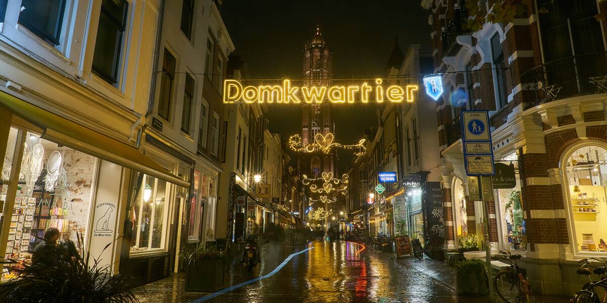 Link naar foto in Flickr: de Domtoren vanuit de Zadelstraat bezien. Met verlichting waarop staat 'Domkwartier'.