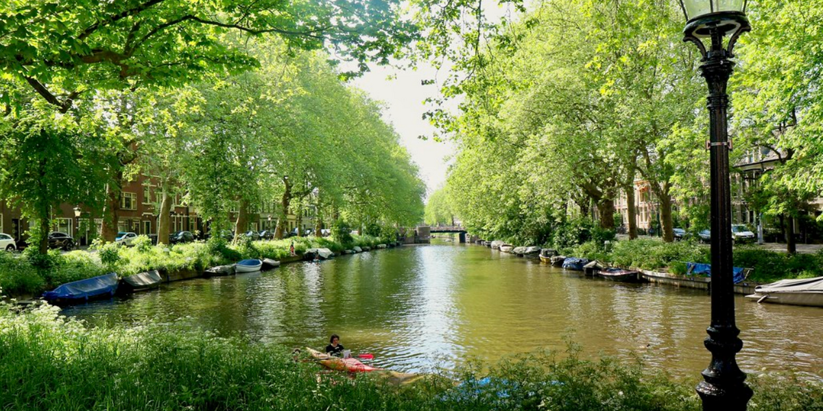 Link naar foto in Flickr: kanoër in het water bij de Van Asch van Wijckade.