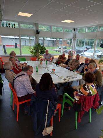 Foto van oud-bestuurders aan een tafel tijdens een excursie van de VOR.