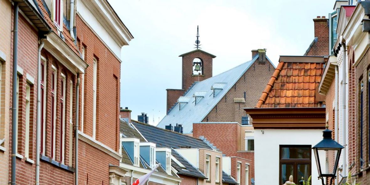 Link naar foto in Flickr: zicht op de toren van de Westerkerk met daken van andere panden op de voorgrond. 